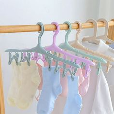 four pairs of baby socks hanging on a wooden rail