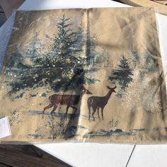 two deer standing next to each other in front of a tree on a piece of paper