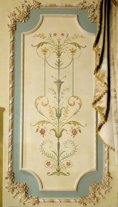 an ornately decorated wall hanging in the corner of a room with curtains and drapes