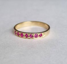 a gold ring with pink stones on it