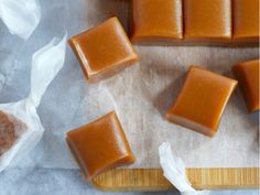 four pieces of soap sitting on top of a wooden cutting board next to some wax paper