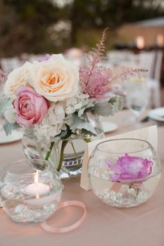 a vase filled with flowers sitting on top of a table next to plates and glasses