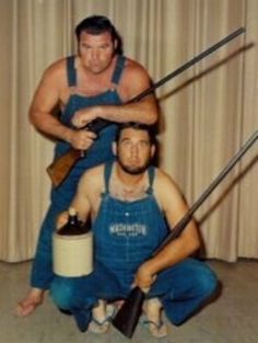 two men sitting on the floor with swords in their hands and one holding a beer