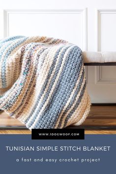 a crocheted afghan sitting on top of a wooden bench next to a white door