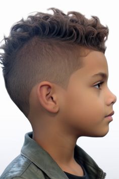 For boys with curly hair, the curly faux hawk is a fun and edgy option. The sides have a skin fade, which highlights the curly top. Applying sea salt spray can. Click here to check out more trendiest boys haircuts for school. Curly Faux Hawk Boy, Mohawk Boys Curly Hair, Faux Hawk For Boys, Curly Mohawk Hairstyles For Boys, Toddler Faux Hawk Little Boys, Boys Haircut Faux Hawk, Curly Hair Mohawk Boys, Curly Haircut For Boys, Boys Short Haircut Kids Fade