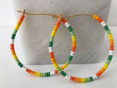 Colorful glass tropical, orange, green, and white beads adorn a gold hoop earring. These are lightweight and versatile earrings. Multicolor Small Hoop Beaded Earrings For Everyday, Everyday Multicolor Small Hoop Beaded Earrings, Handmade Colorful Summer Hoop Earrings, Colorful Handmade Hoop Earrings For Summer, Handmade Colorful Hoop Earrings For Summer, Colorful Beaded Hoop Earrings For Everyday Summer, Orange Hoop Earrings With Colorful Beads, Multicolor Small Hoop Jewelry With Spacer Beads, Colorful Handmade Hoop Earrings For Beach