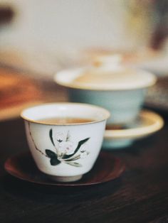 two coffee cups sitting on top of a wooden table