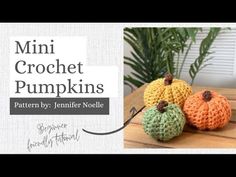 three crocheted pumpkins sitting on top of a wooden table