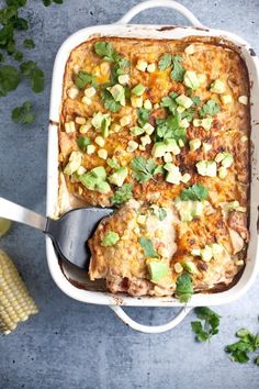 a casserole dish with corn on the cob and avocado garnish