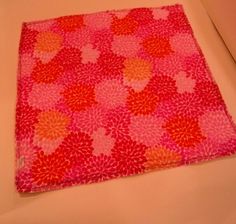 a pink and red flowered area rug sitting on top of a white countertop