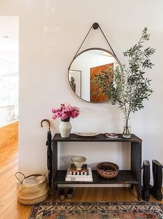 a vase with flowers on top of a table next to a mirror and other items