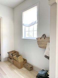 an empty room with some boxes on the floor and a window in the corner above it