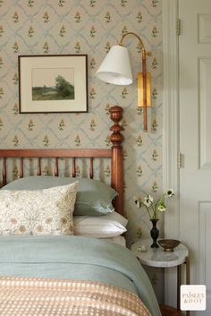 a bed room with a neatly made bed and a painting on the wall