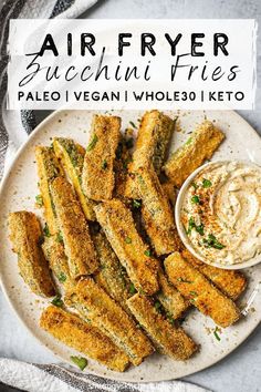 air fryer zucchini fries on a white plate with ranch dip in the middle