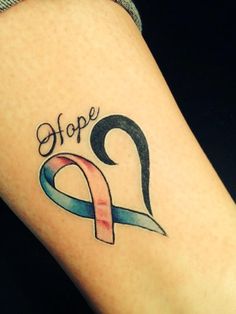 a woman's arm with a tattoo that says hope and a ribbon on it