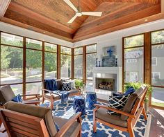 a living room filled with lots of furniture under a wooden ceiling mounted flat screen tv