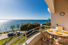 a balcony with table and chairs overlooking the ocean