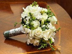 a bridal bouquet sitting on top of a wooden table