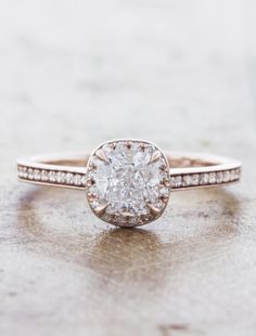 an engagement ring with a cushion cut diamond in the center