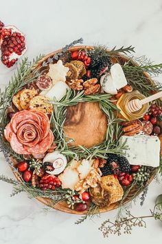 a platter filled with cheese, meats and vegetables on top of a table