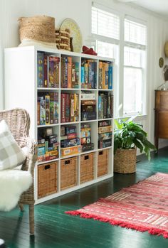 a living room filled with lots of furniture and bookshelves next to a window