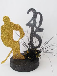 a cake topper with the number twenty five and a figure holding a baseball bat