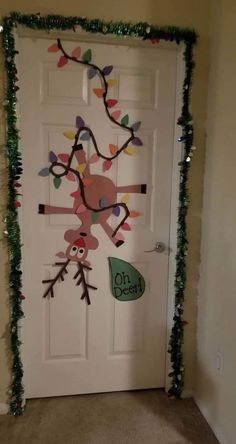 the door is decorated with christmas lights and garlands, including an owl hanging from a tree