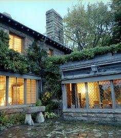 a stone building with lots of windows and plants growing on it