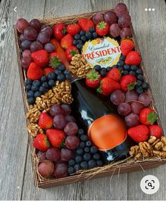 a basket filled with fruit and wine on top of a wooden table