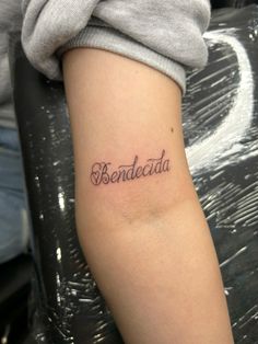 a person with a tattoo on their arm that says bendocda in cursive font