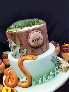 there is a cake decorated with an image of a tree stump and snakes on it