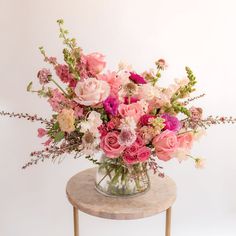 a vase filled with pink and white flowers on top of a table