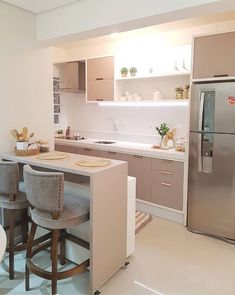 a kitchen with two stools and a refrigerator