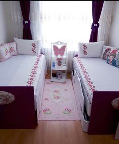 a bedroom with two twin beds and a pink rug on the floor next to a window