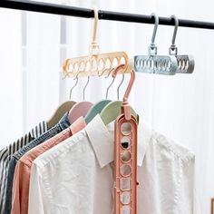 a rack with clothes hanging on it in front of a window and a white curtain