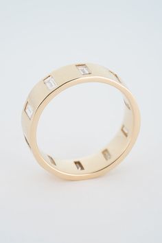 a yellow gold wedding ring with baguettes on the sides and diamonds in the middle