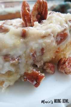 a close up of a piece of cake on a plate with pecans in the background