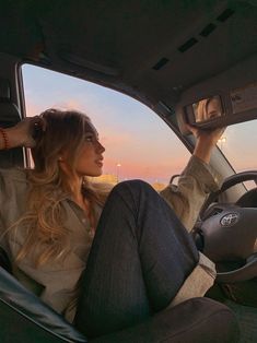 a woman sitting in the driver's seat of a car