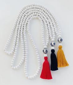 Handmade MALA necklaces with wooden beads, cotton thread tassel and decorated ceramic bead. I used 108 8mm. Choose your tassel color! Red Blue Mustard The length of the malas is 47cm including the tassel. White Beaded Necklaces With Tassels As Gift, White Beaded Necklaces With Tassels For Gift, White Beaded Tassel Necklaces As Gift, White Bohemian Beaded Necklace With Tassels, White Wooden Beads Necklace For Meditation, White Wooden Beads Bohemian Mala, Beads Mala, Mala Necklace, Mala Beads