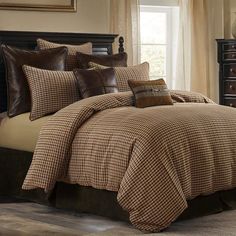 a bed with brown and tan plaid comforters