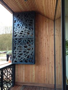 an open door on the side of a building with wood paneling and metal railings