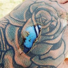 a man's hand with a blue and white piece of ink on the inside of it