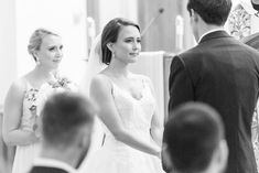 a bride and groom standing at the alter during a wedding ceremony in black and white