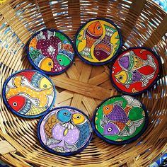 four colorful fish painted on coasters in a basket