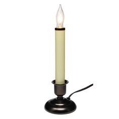 a lit candle on a black stand with a white light in the middle and a cord attached to it