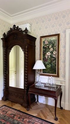 a large mirror sitting on top of a wooden dresser next to a lamp and painting