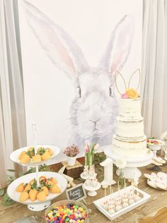 a table topped with cakes and desserts covered in bunny ears