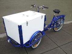 a blue and white bike with a cooler on the back