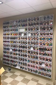 there is a wall full of magazines on display in the office building with checkered flooring