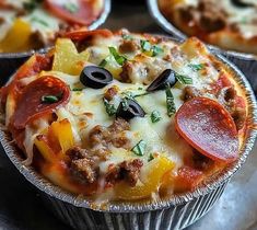 several different types of pizza in tins on a table